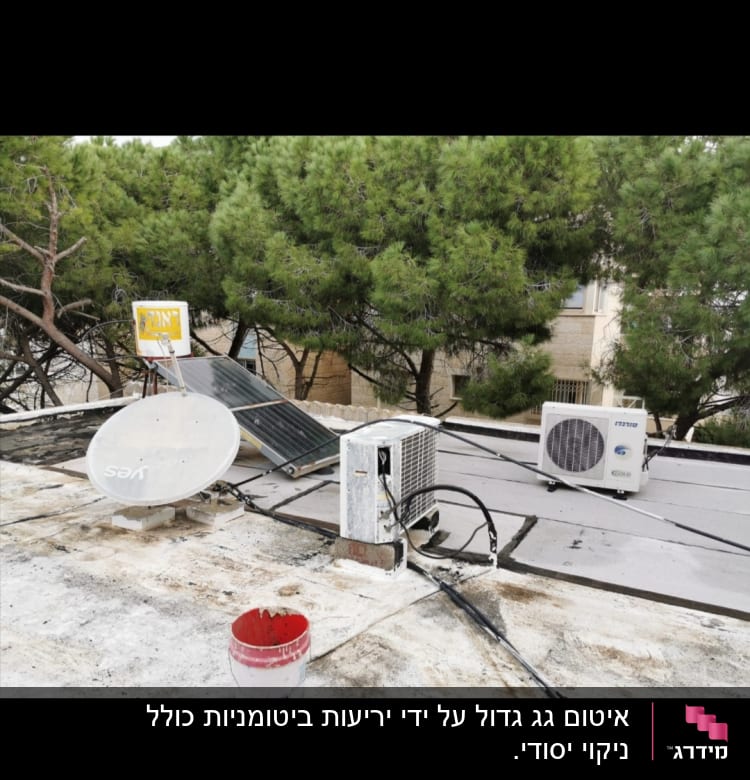 דלי צבע אדום על גג עם ציפוי איטום